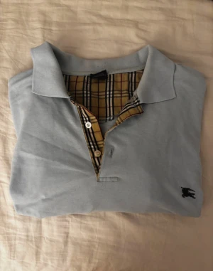 Ljusblå Burberry pikétröja XXL - Säljer en ljusblå pikétröja från Burberry i storlek XXL. Tröjan har loggan och är i fint skick❤️