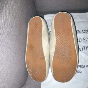 Golden Goose Superstar sneakers vita - Säljer ett par golden goose superstar. Tvär feta skor men väldigt använda, dom är 100% äkta men säljs så billigt pågrund av skicket på dom. Finns fåtal hål i sulan annars ser dom bra ut riktigt feta!