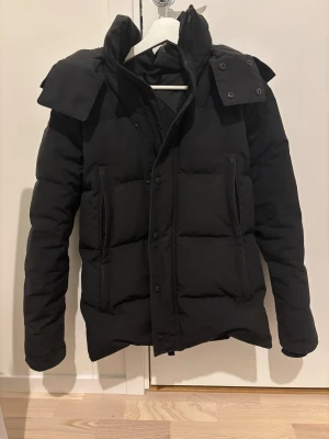 Canada goose wyndham parka - Jackan passar xs-s och har lite defekter men som knappt e synligs i när man har på sig den, märker knappt av d. Pris går att sänkas vid snabbaffär. Svart pufferjacka med hög krage och avtagbar huva. Jackan har ribbstickade muddar i ärmsluten, två stora fickor med dragkedja och knappar framtill. Perfekt för kalla dagar och har en stilren, modern look.
