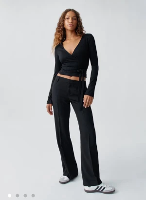 Svarta kostymbyxor TALL - Svarta kostymbyxor från Gina Tricot med rak passform. Byxorna har låg midja, pressveck och hällor för bälte. I Tall modellen och är välidgt långa på mig som är 172 dom går liksom under fötterna men går att sy upp om man är kortare, passar nog upp till 176 eller nått. Endast använda en gång