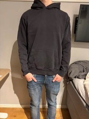 Svart hoodie från Replay - Svart hoodie från Replay med klassisk huva. Mjuk bomullskänsla och ribbade muddar vid ärmslut och nederkant. Snyggt minimalistisk design utan tryck, med Replay-logga på huvan.