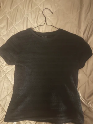 Svart ribbad blus med kort ärm - Säljer en svart blus från H&M med ribbad struktur och korta ärmar. Väl använden men i toppen skick🥰👍