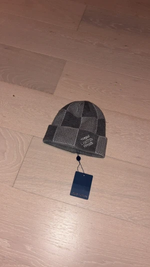 Grå rutig mössa - Fin style inför vintern håller en varm och har en väldigt unikt material och även utseende.