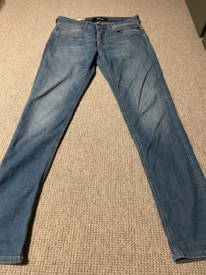 Replay w27 L30 - Snygga ljusblå jeans från Replay, modell Willbi med slim fit och regular passform. Klassisk femficksdesign, med Replay-logga på myntfickan och snygga slitningar. Perfekt för dig som gillar en smal siluett och stilren look.