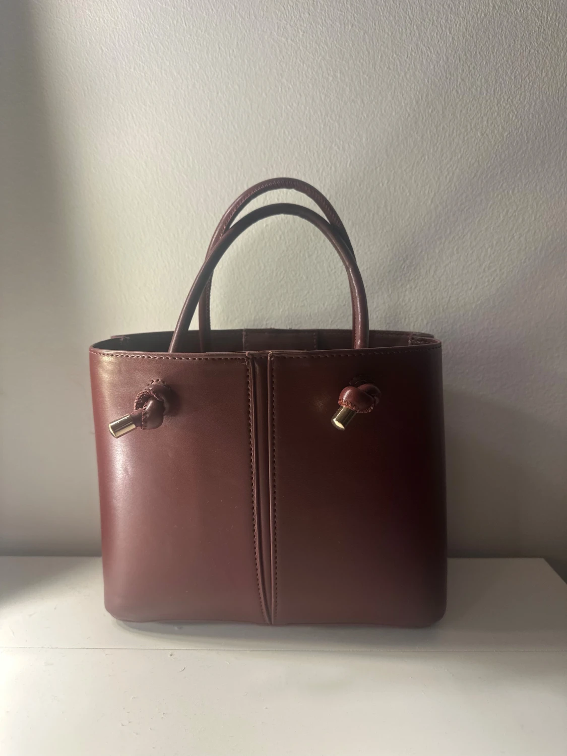 Vinröd handväska med gulddetaljer