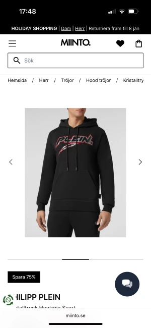 Svart hoodie från Philipp Plein med tryck - Svart hoodie från Philipp Plein med stort rött och vitt logotryck på bröstet. Huva med röda detaljer och emblem baktill. Klassisk känguruficka och dragsko i halsen. Perfekt för dig som gillar streetwear med attityd. Väldigt litet hål på ryggen syns inte alls 