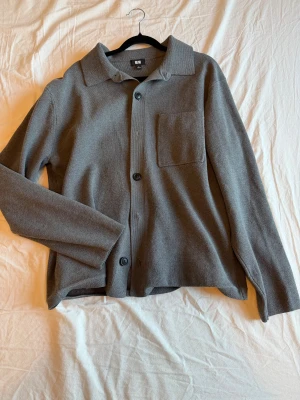 Uniqlo kofta - Mörkgrå kofta från uniqlo i snygg overshirt design och mjukt tyg. Storlek M. Mycket bra skick.