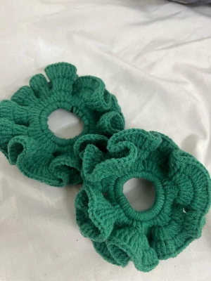 Gröna stickade örhängen med volang - Unika gröna örhängen med stickad volangdesign. De är runda och har en cool, handgjord känsla som sticker ut. Perfekt för dig som gillar färg och vill ha något annorlunda till din stil.