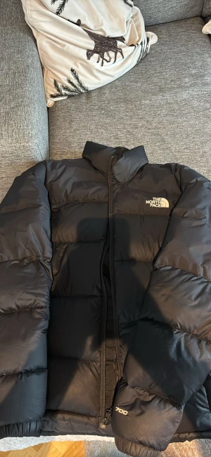 Svart pufferjacka från The North Face - Säljer en svart pufferjacka från The North Face, modell 700.  Inga hål eller liknande som ny 