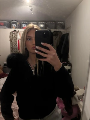 Kofta/jacka - En svart koft/jacka med fejk päls på luvan.