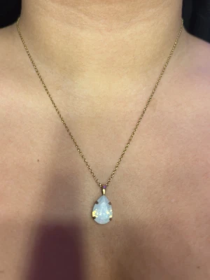 Halsband  - Ett halsband från Caroline svedbom, halsbandet är i guld med en vit sten som skiftar lite färg i olika ljus, har knappt använt den då jag inte bär halsband så ofta.