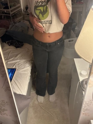 svarta bootcut jeans - Säljer ett par svarta jeans med bootcut passform och låg midja. Jeansen är i klassisk denim med fem fickor och har en snygg tvättad look. Perfekta för dig som gillar retrovibbar och vill ha ett par jeans som sitter tajt upptill och släpper vid benen. Jeansen har knappt använts och är fortfarande i bra skick. Säljer för har inte kommit så mycket tills användningen till mig för har redan mycket jeans 💕kostar originellt 600