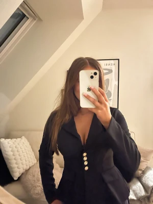 Svart kavaj med guldknappar - Snygg svart kavaj med guldknappar framtill. Materialet på kavajen skulle jag säga är lite mjukare och inte som en ”vanlig” kavaj.