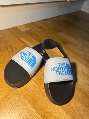 Tofflor/ The north face  - Helt nya, med prislapp. Det står 44,5 men de passar 43 inte mer eller mindre. Ny pris är 550kr