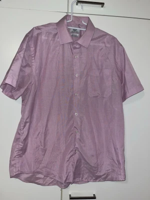 Kauluspaita 43/44 XL - Liilahtavan värinen lyhythihainen kauluspaita. Edessä rintatasku. Osassa kohtaa esiintyy pientä nukkaa. Koko 43/44 XL. Kaikai n 62cm, pituus n 76cm. Eläintalous MMM, lisätietoja saa kysymällä Katsothan myös muut ilmoitukseni Tarjoa 