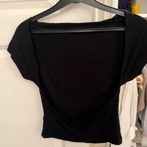 Svart topp med öppen rygg - Säljer en svart topp med öppen rygg. Den är lite för liten för mig därför säljer jag den💗