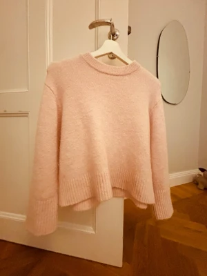 Ljusrosa stickad tröja Gina Tricot - Supermjuk ljusrosa stickad tröja från Gina Tricot. Tröjan har en relaxed fit med ribbade muddar vid ärmslut och nederkant samt rund halsringning. Perfekt för mysiga dagar och enkel att styla med jeans eller kjol.