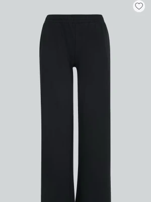 Svarta lågmidjade mjukisbyxor från BikBok - Säljer ett par svarta mjukisbyxor från BikBok i storlek L. Byxorna har breda ben, elastisk midja med snörning och är tillverkade i mjukt bomullsmaterial. Perfekta för chill dagar eller när du vill ha det extra bekvämt.