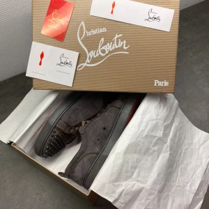 Loubs - Tja! Har ett par ritkigt schyssta loubs i den gråa nyansen. Ganska använda och en sådan plast ring har åkt av på vänster skon men ingen större skada. Box och kort ingår med skorna, storlek 42. Fraktar boxen i en annan låda så ingen skada sker under frakten. Skickas samma dag som du köper!