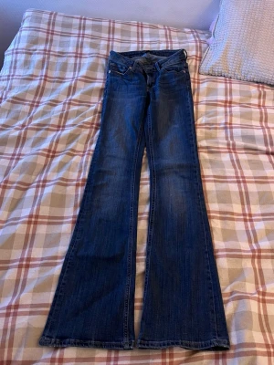 Blåa bootcut jeans - Blåa bootcut jeans - lågmidjade. I bra skick förutom ett mindre hål på vänster baksida ( se bild 4 ) men inget man tänker på