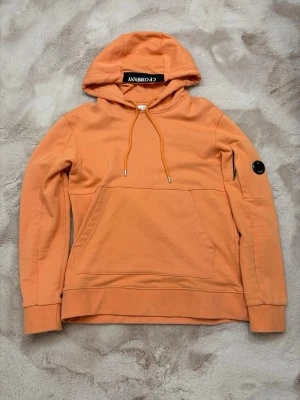 C.P. Company - C.P. Company hoodie i orange. Hoodien är i superfint skick! Storleken är S men passar M/L eftersom den är oversized.