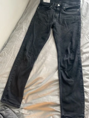 Svarta slim jeans från H&M, 31/32 - Säljer ett par svarta slim fit jeans från H&M i storlek 31/32. Klassisk femficksmodell med raka ben och knappgylf. Jeansen är i ett mjukt bomullsmaterial med lite stretch för extra komfort. Perfekta till sneakers eller boots. Passar perfekt för en stilren outfit. Priset kan diskuteras, fråga gärna om du har några frågor!
