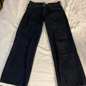 Mörkblå low wide jeans från gina tricot - Säljer ett par mörkblåa low wide jeans från gina tricot, Perfekta för dig som gillar tidlös stil och vill ha ett par riktigt schyssta jeans. Knappt använda, mycket bra skick