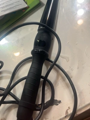 Svart locktång med digital display - Säljer en svart locktång med digital display och ergonomiskt handtag. Tången har sladd och knappar för temperaturinställning. Perfekt för att skapa snygga lockar och vågor i håret.