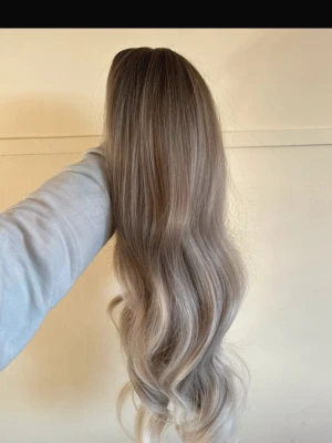 Wig - Bilderna visar en peruk eller löshår i bruna och blonda nyanser med mjuka vågor