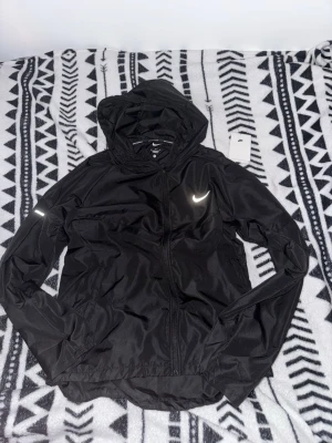 Nike Miler Windbreaker - Säljer denna Nike jacka i storlek M som endast är testad men kunde inte returneras då tiden gått för långt. Är för liten för mig men annars i top skick