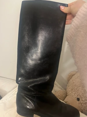 Svarta höga skinnstövlar - Säljer ett par klassiska svarta stövlar boots i stl 39. Köpta second hand så vet it vad det är för märke.