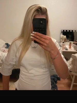 Vit omlottopp med öppen rygg och knyt - Säljer en vit omlottopp med öppen rygg och breda knytband bak. Toppen har halvlånga ärmar och är croppad i modellen. Perfekt för dig som vill ha en enkel men ändå unik topp till sommaren.