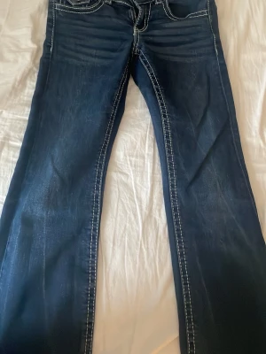 Mörkblå bootcut jeans med kontrastsömmar - Säljer ett par mörkblå jeans och bootcut passform. Dom är i storlek 152 och passar mig som är 1,59 cm vi kan diskutera priset.