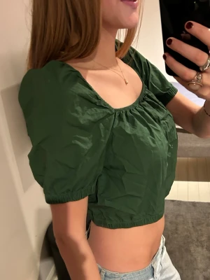 grön topp med puffärmar - grön topp med puffärmar storlek S. jag är 175 cm lång, hör av er vid frågor! perfekta festtoppen!