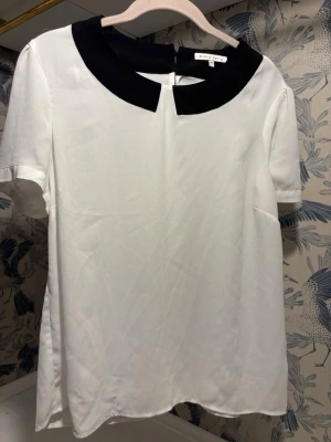 Vit blus med svart krage - En superfin blus från mint&berry som går att använda till vardags eller finare event! Passar superbra du till våren och med en kofta till!