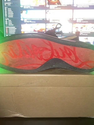 Christian Louboutin svarta spikes sneakers - Säljer ett par svarta sneakers från Christian Louboutin med ikonisk röd sula och svarta nitar över hela tån. Skorna har snörning och är tillverkade i mocka med coola detaljer som ger en edgy vibe. Kommer med originalkartong och dustbag. Använda på bröllop en gång.