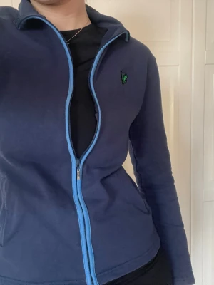Lyle & Scott zip-up - En mörkblå zip-up tröja från Lyle & Scott. Inga defekter.