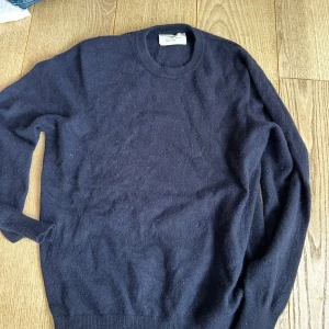  Kashmir mörkblå stickad tröja från Zara  - Mysig mörkblå stickad tröja från Zara med rund halsringning och långa ärmar. Perfekt för lager-på-lager och passar till både jeans och kjol. Enkel och stilren design som funkar året runt.  