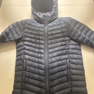 Mörkblå dunjacka Peak Performance - Mörkblå peak performance jacka i storlek 170. Saknas en gummibit på snöret till dragkedjan annars i fint skick.