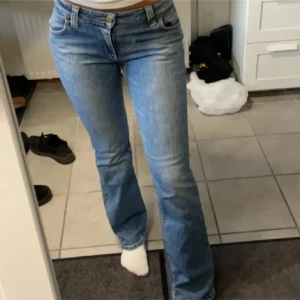 Blå bootcut jeans från Lee - Säljer ett par klassiska blå bootcut jeans från Lee med låg midja. Jeansen har fem fickor, snygga sömmar och Lee-logga på bakfickan. Tillverkade i mjukt denimtyg! 