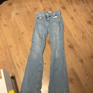 Ljusblå bootcut jeans från 157 - Snygga ljusblå jeans från 157 med klassisk femficksdesign och bootcut-ben. Jeansen har normalhög midja, dragkedja och knapp framtill samt detaljerade sömmar. Perfekta för dig som gillar en retroinspirerad look med lite utsvängda ben.