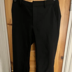 Svarta kostymbyxor med lite utsvängda ben - Snygga svarta kostymbyxor med lite utsvängda ben från bikbok. Jag har även sytt in dom så dom har blivit lite mer lågmidjade.