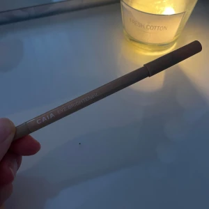 CAIA Eye Brightener penna - En beige ögonpenna från CAIA, kallad Eye Brightener. Pennan har en krämig, ljus nyans som är perfekt för att ljusa upp vattenlinjen eller inre ögonvrån. Smidig att applicera och ger en piggare look direkt.