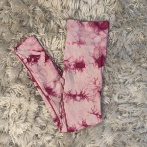 Rosa tie-dye leggings - Supersnygga leggings i rosa tie-dye mönster. Hög midja och stretchigt material som sitter tajt och bekvämt. Perfekta för träning eller chill. Tillverkade i 95% polyamid och 5% elastan för maximal rörelsefrihet.