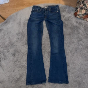 Blå bootcut jeans från Zara Woman - Snygga blå jeans från Zara Woman Premium Denim Collection i klassisk bootcut-modell. Jeansen har fem fickor, passar både storlek 34 och mig som 36 och är tillverkade i mjukt bomullsdenim med lätt tvättad look. Perfekta för dig som gillar en tidlös och trendig stil.