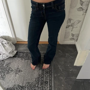 Mörkblå bootcut jeans från H&M  - Ett par mörkblå bootcut jeans från H&M i storlek 32. Lågmidjade och bootcut form. Använda få gånger men fortfarande i fint skick. Med mönstrade fickor bak.