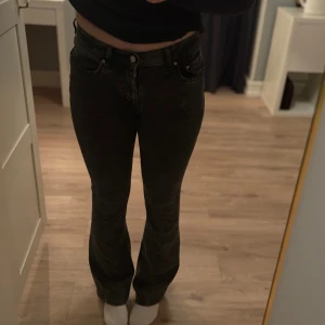 Mörkgråa bootcut jeans från Perfect Jeans - Snygga svarta jeans från Perfect Jeans i bootcut-modell med hög/medel midja. Jeansen har klassisk femficksdesign, bälteshällor och en lätt tvättad finish. Materialet är stretchigt. Andvänd en gång så dom är i väldigt bra skick😊.                          Sista bilden visar hur grå färgen är mot en svart tröja. 