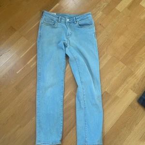 Ljusblå regular fit jeans från &Denim - Säljer ett par ljusblå jeans från &Denim i regular fit. Klassisk femficksmodell med raka ben och normal passform. Jeansen är tillverkade i bomullsdenim och har en enkel, stilren look som passar till det mesta.