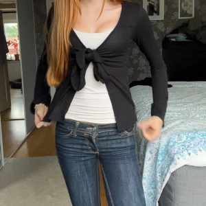 Svart kofta med knyt framtill - Säljer en svart kofta med lång ärm och snygg knytning framtill. Koftan har en figurnära passform och är perfekt att både ha över ett linne eller utan. Enkel och stilren design som passar till allt. Köpt för 250 från Gina tricot.