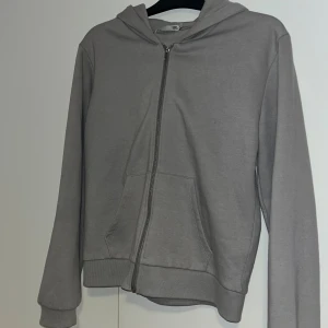 Grå hoodie med dragkedja  - En stilren grå hoodie från Lager 157 i storlek M.  Tillverkad i mjuk bomullsblandning. Långärmad och enkel design som passar till det mesta. Säljer då den inte kommer till användning längre 💗